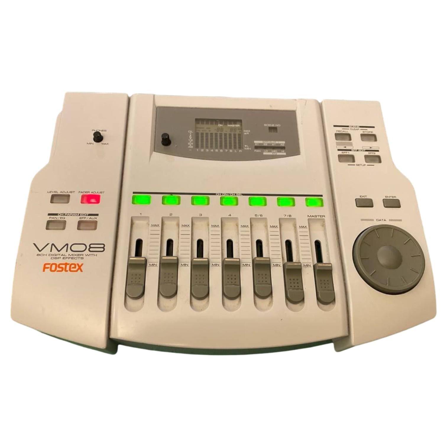 mixer digitale Fostex VM08 a 8 canali con fader illuminati e display centrale, pannello frontale in colore grigio chiaro.